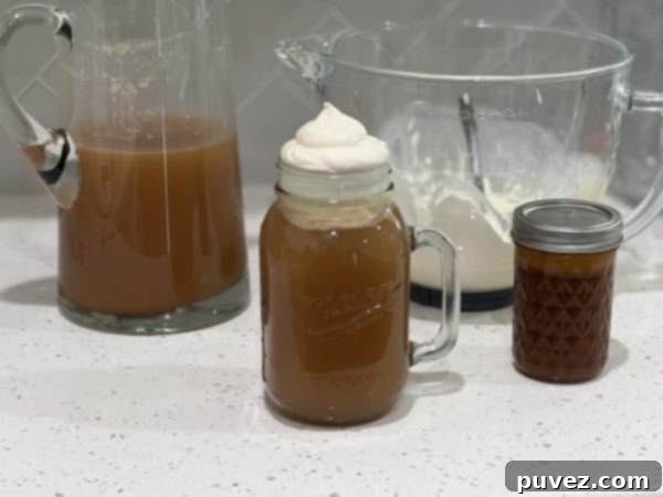ButterBeer in a mason jar cup, in a pitcher, and a glass mixing bowl with the cream topping. A complete set of homemade Butterbeer.