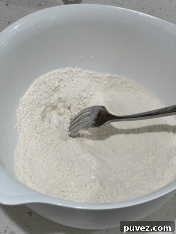 Close-up of a bowl containing whisked flour mixture, ready for the wet ingredients.