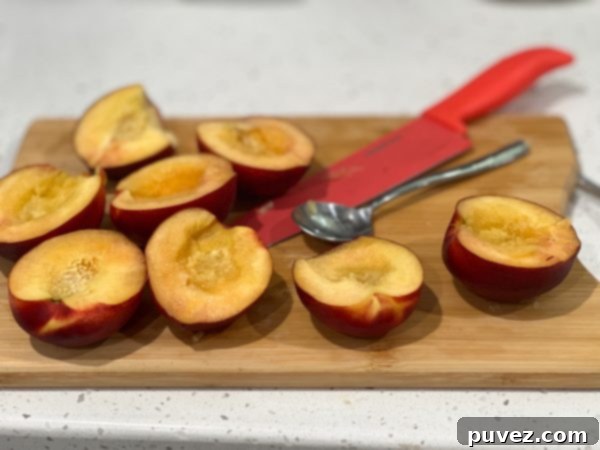 peaches halved and pitted on a cutting board
