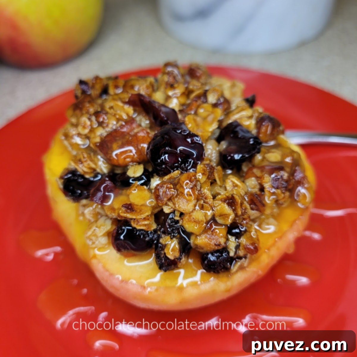 baked apple topped with crunchy granola on a red plate