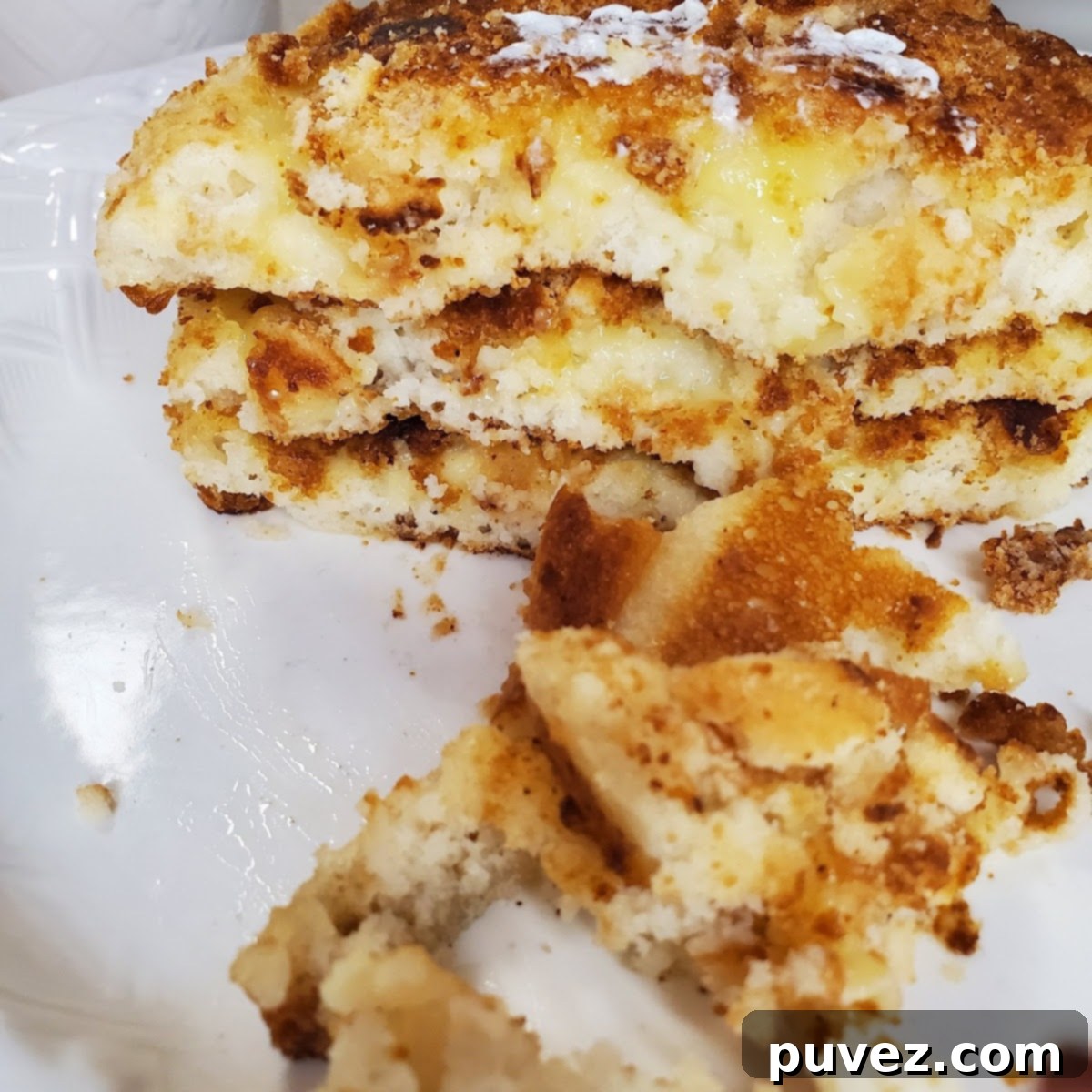 Three freshly cooked banana pudding pancakes on a plate, ready to be served