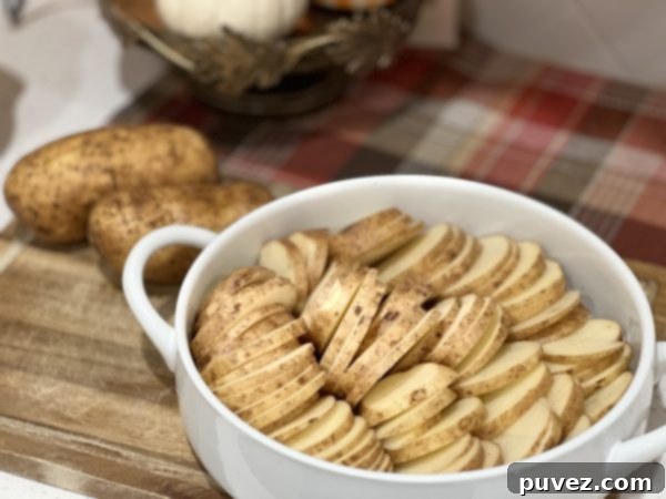 potatoes sliced and arranged in the baking dish, ready for the sauce