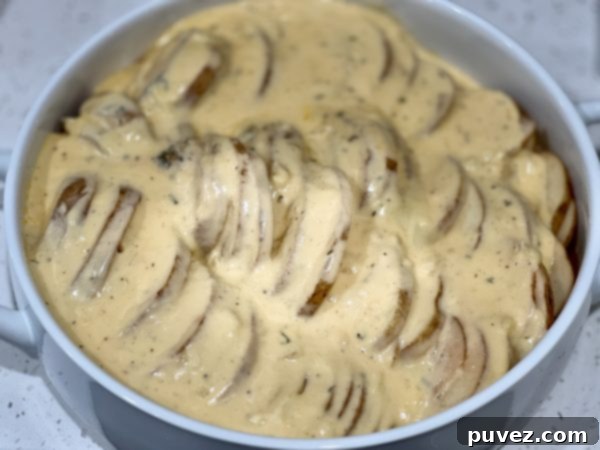 Creamy au Gratin Potatoes before baking, covered in rich sauce