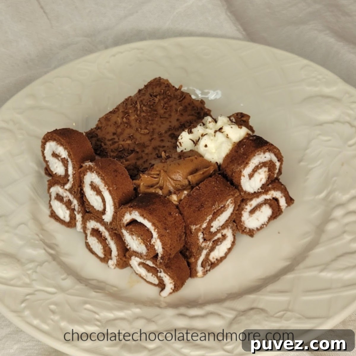 Close-up of neatly sliced chocolate Swiss rolls, showing the perfect spirals of cake and cream, ready to line the dish