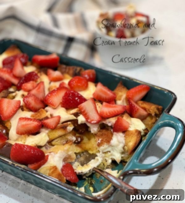 A beautifully baked Strawberries and Cream French Toast Casserole, garnished with fresh strawberries