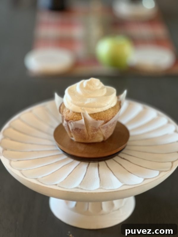 Two jumbo vanilla cupcakes, one frosted and one plain, showcasing the deliciousness.