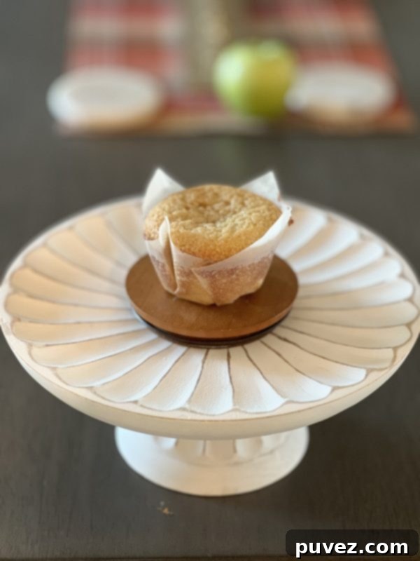 A baked jumbo vanilla cupcake cooling on a wire rack, waiting for its frosting.