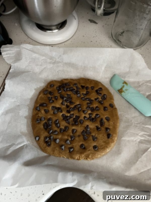 Chewy Chocolate Chip Cookie Cake dough ona cookie sheet before baking