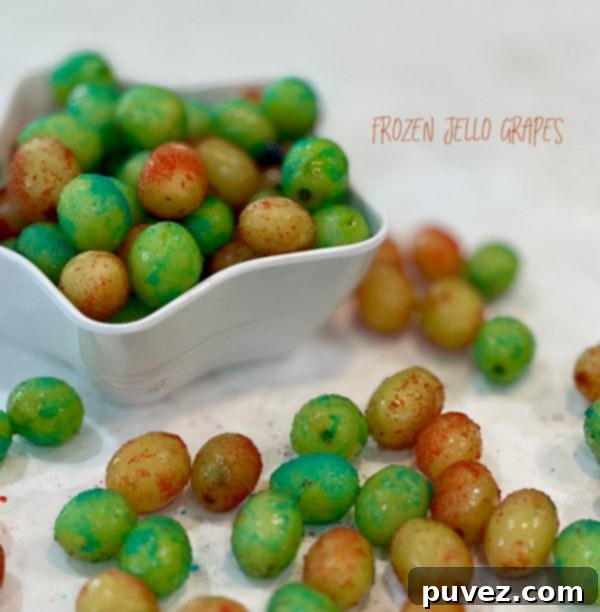Frozen Jello Grapes - A bowl of green and red grapes coated in vibrant Jell-O powder