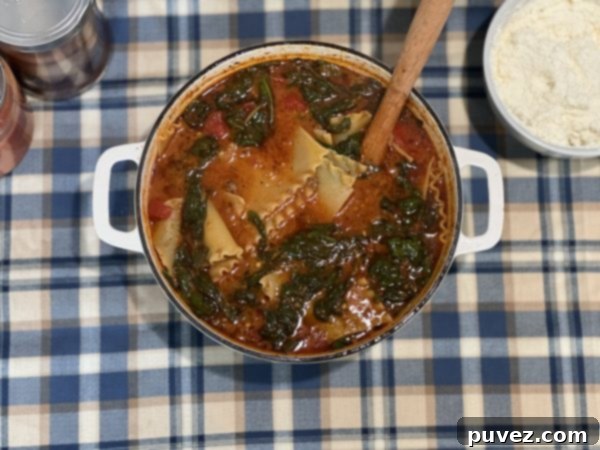 A bowl of Lasagna Soup with a creamy cheese topping