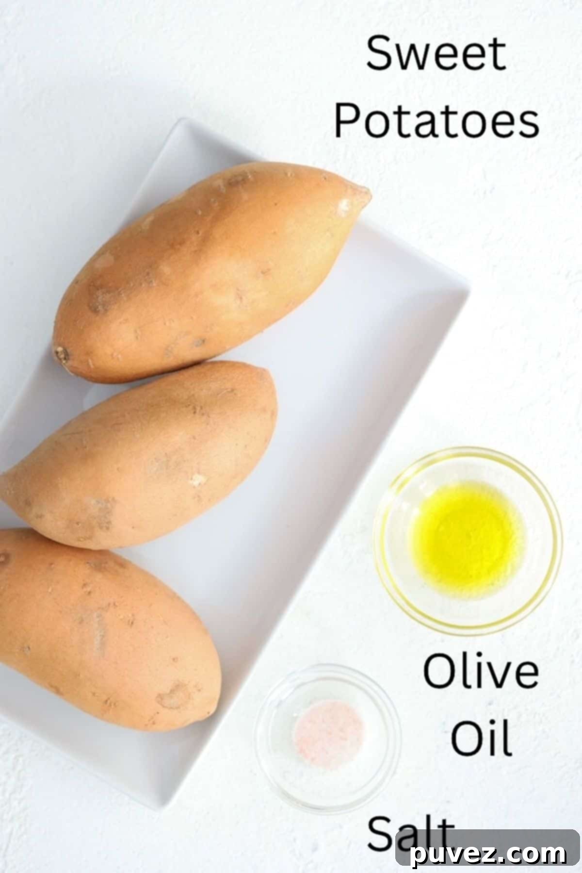 Ingredients for Roasted Sweet Potatoes, clearly labeled: a whole sweet potato, a bottle of olive oil, and a salt shaker.
