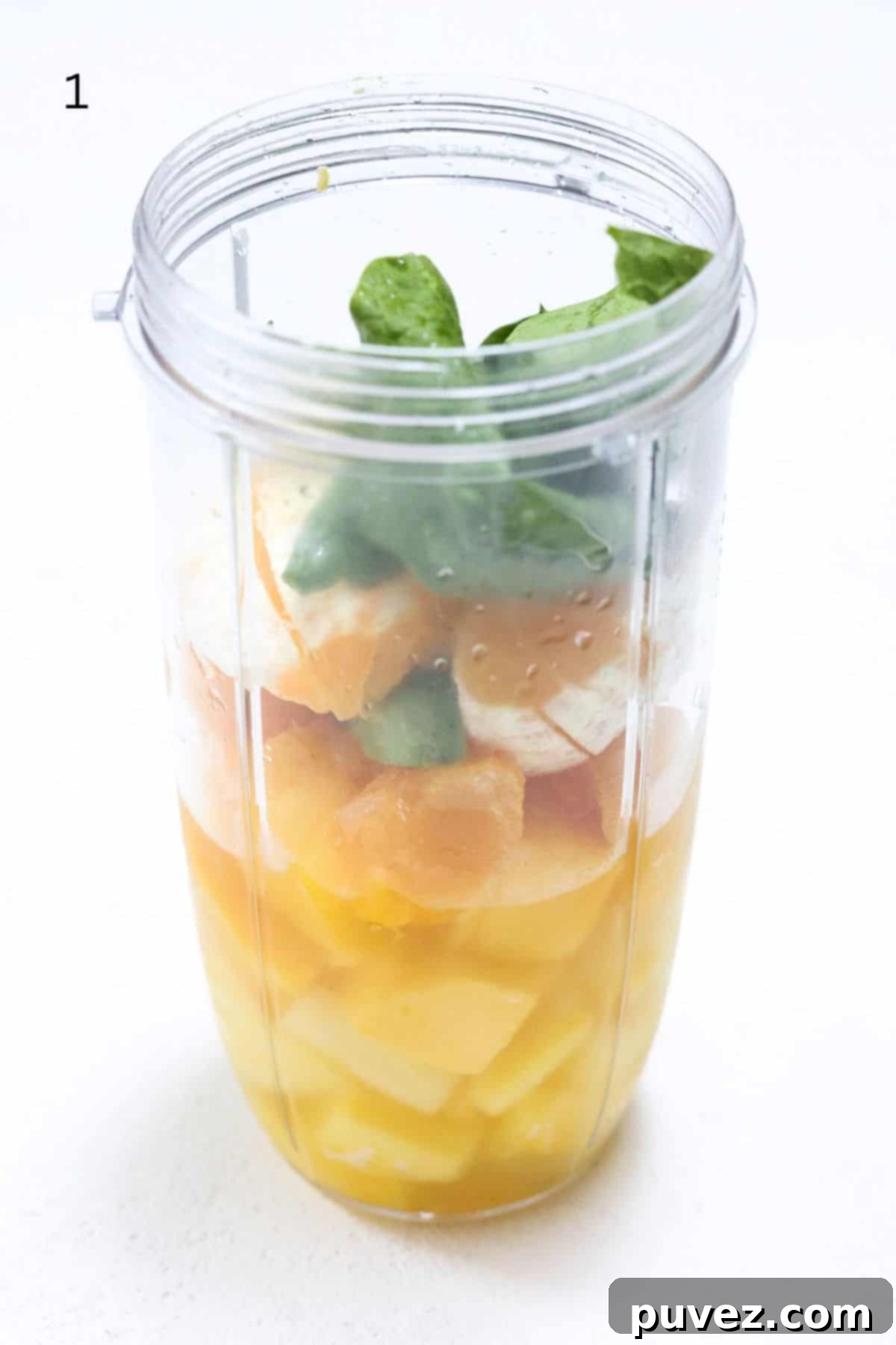Island Green Paradise Smoothie 4 All ingredients for the Island Green Tropical Smoothie loaded into a NutriBullet Pro blender cup, ready for blending.