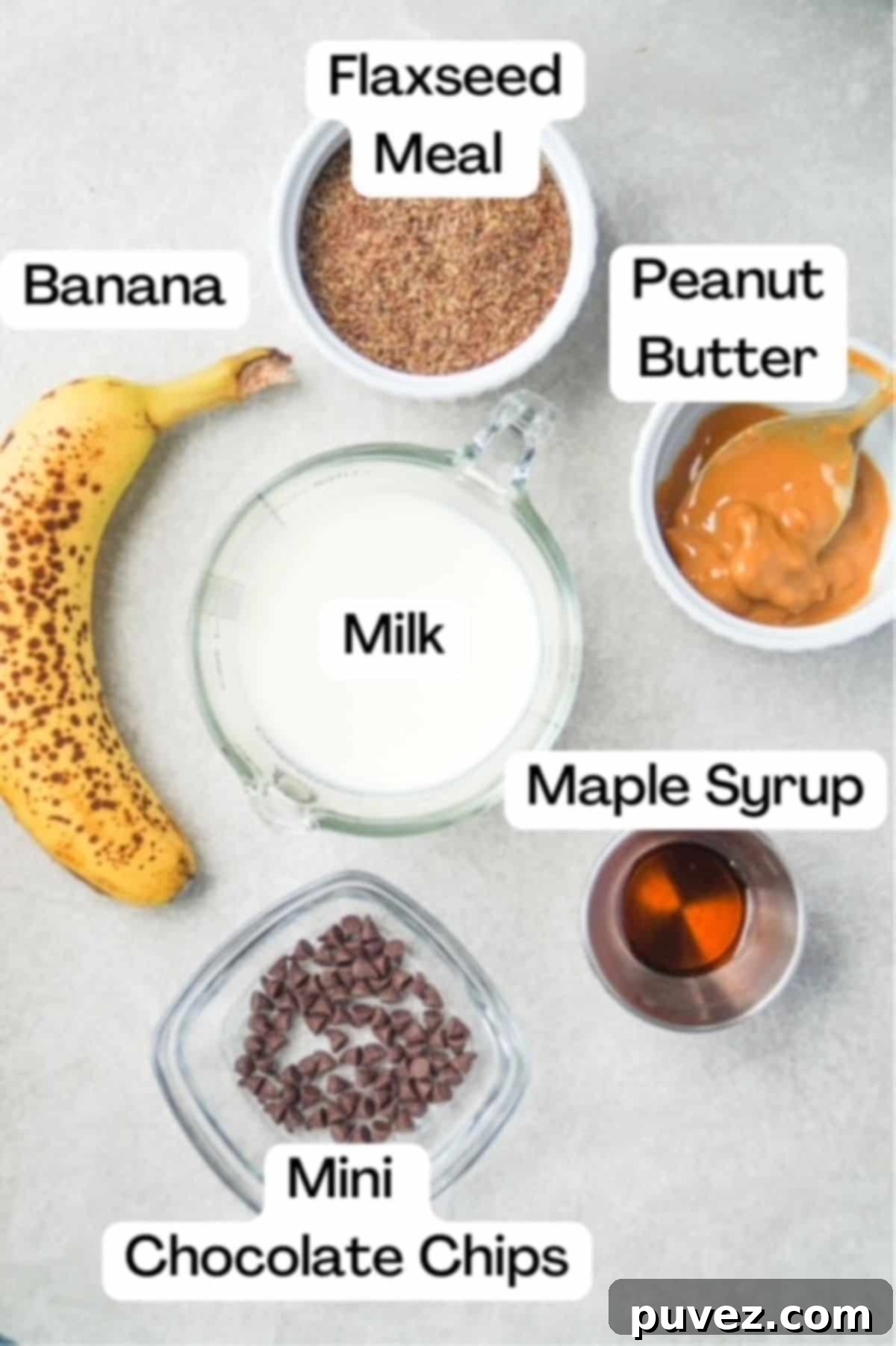 All six key ingredients for easy flaxseed pudding carefully measured out and labeled: one ripe banana, golden flaxseed meal, milk, natural peanut butter, maple syrup, and a small bowl of mini chocolate chips.