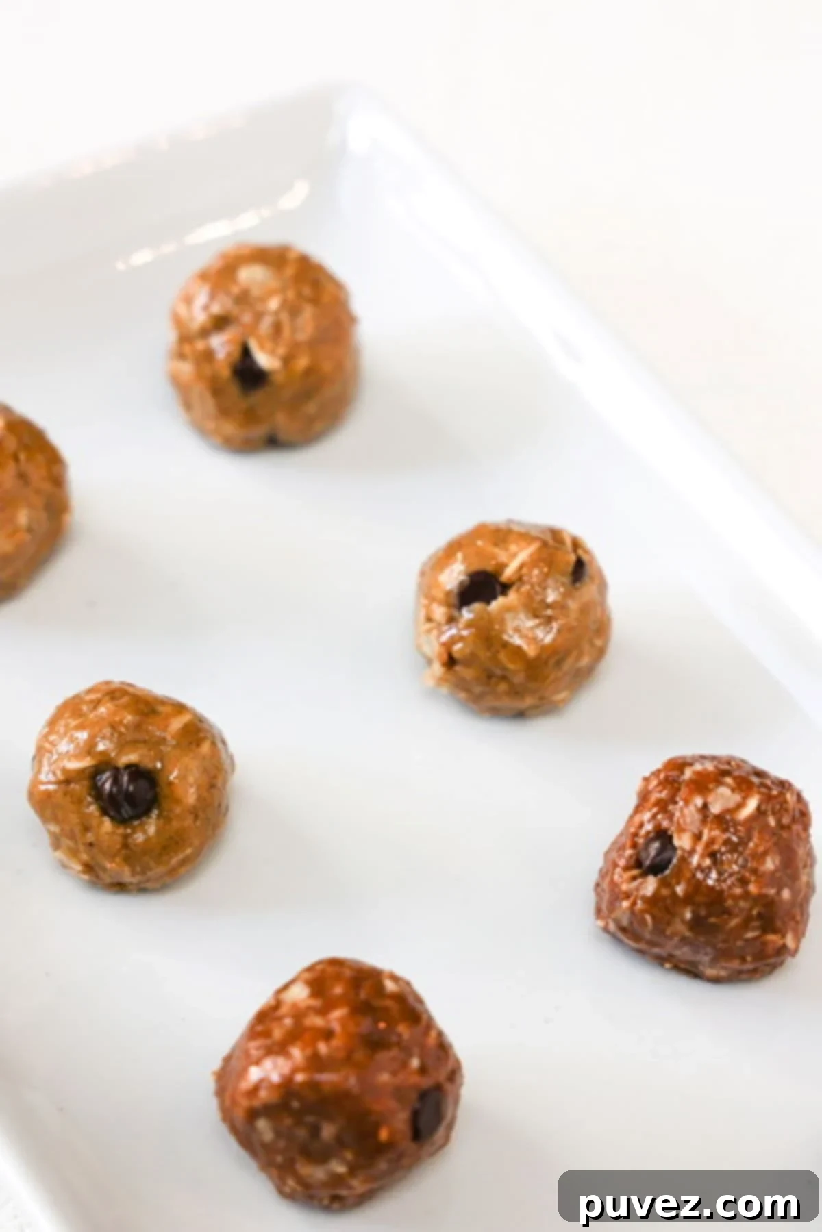 Chocolate bliss balls and protein bliss balls on a white dish.