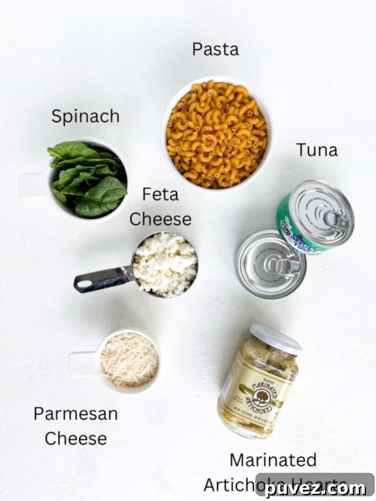 Ingredients for Easy Tuna Pasta recipe, labeled, including pasta, tuna, feta, parmesan, and artichoke hearts.