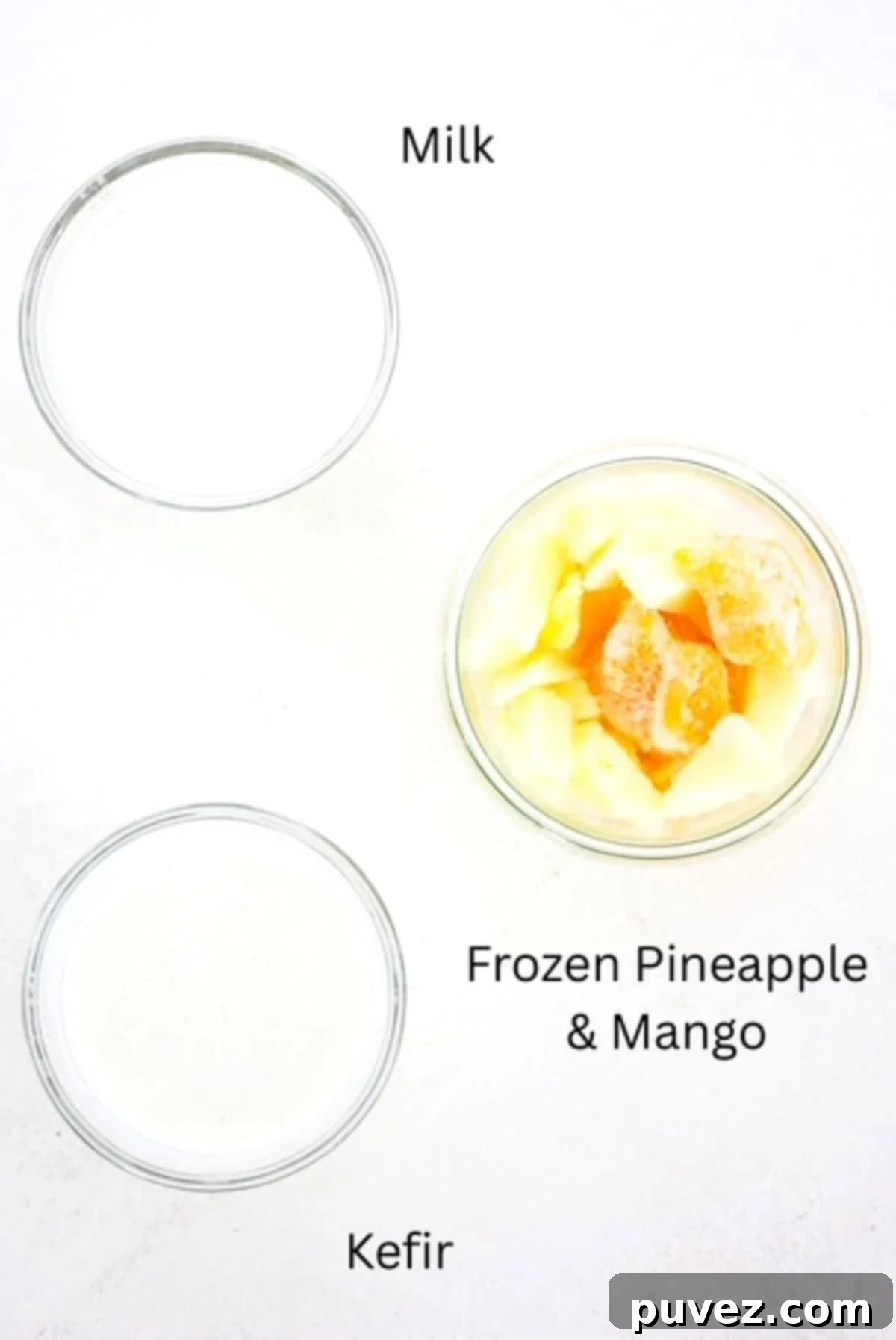 Labeled ingredients for a Mango Pineapple Smoothie: frozen mango, frozen pineapple, milk, and vanilla kefir, ready for blending.