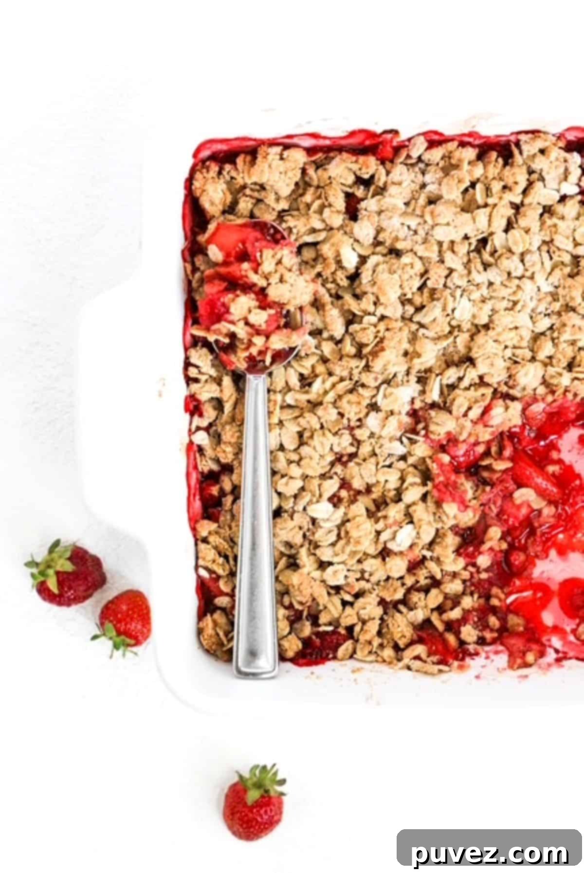 Effortless Strawberry Crumble 2 Top view of baked Strawberry Crumble with a serving spoon.