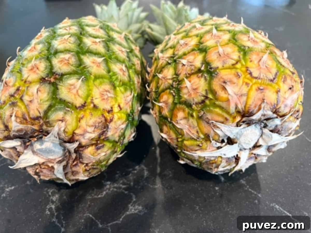 Pick the Perfect Pineapple Every Time 3 Two ripe pineapples laying on their sides next to each other, showing color variation.