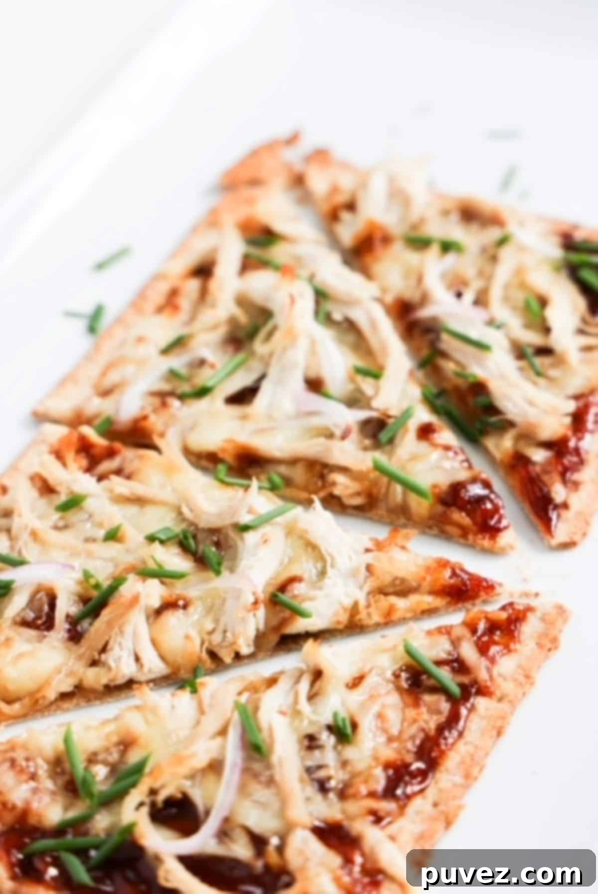 Blazing BBQ Chicken Flatbread in Minutes 2 One bbq chicken flatbread topped with chopped green onion and sliced into four pieces.