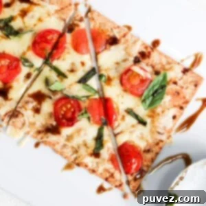 One margherita flatbread sliced. A pizza roller is to the right of the flatbread.