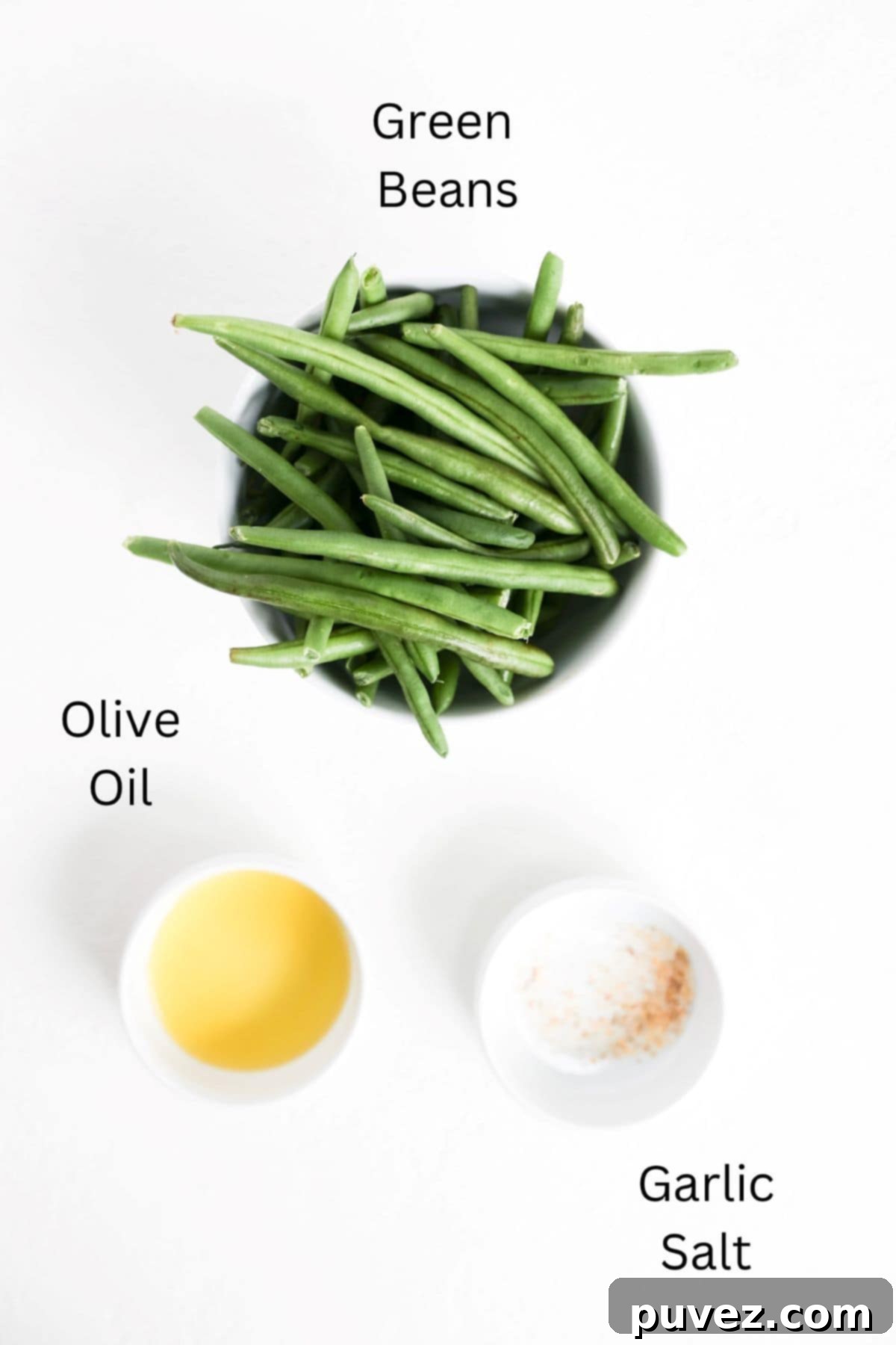 Green beans, olive oil, and garlic salt in separate white prep dishes, labeled.