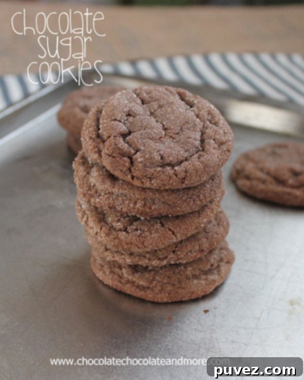 Chocolate Sugar Cookie dough rolled into balls and coated in sugar, ready for baking