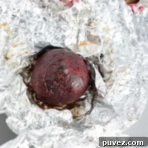 One roasted beet on top of a piece of foil.