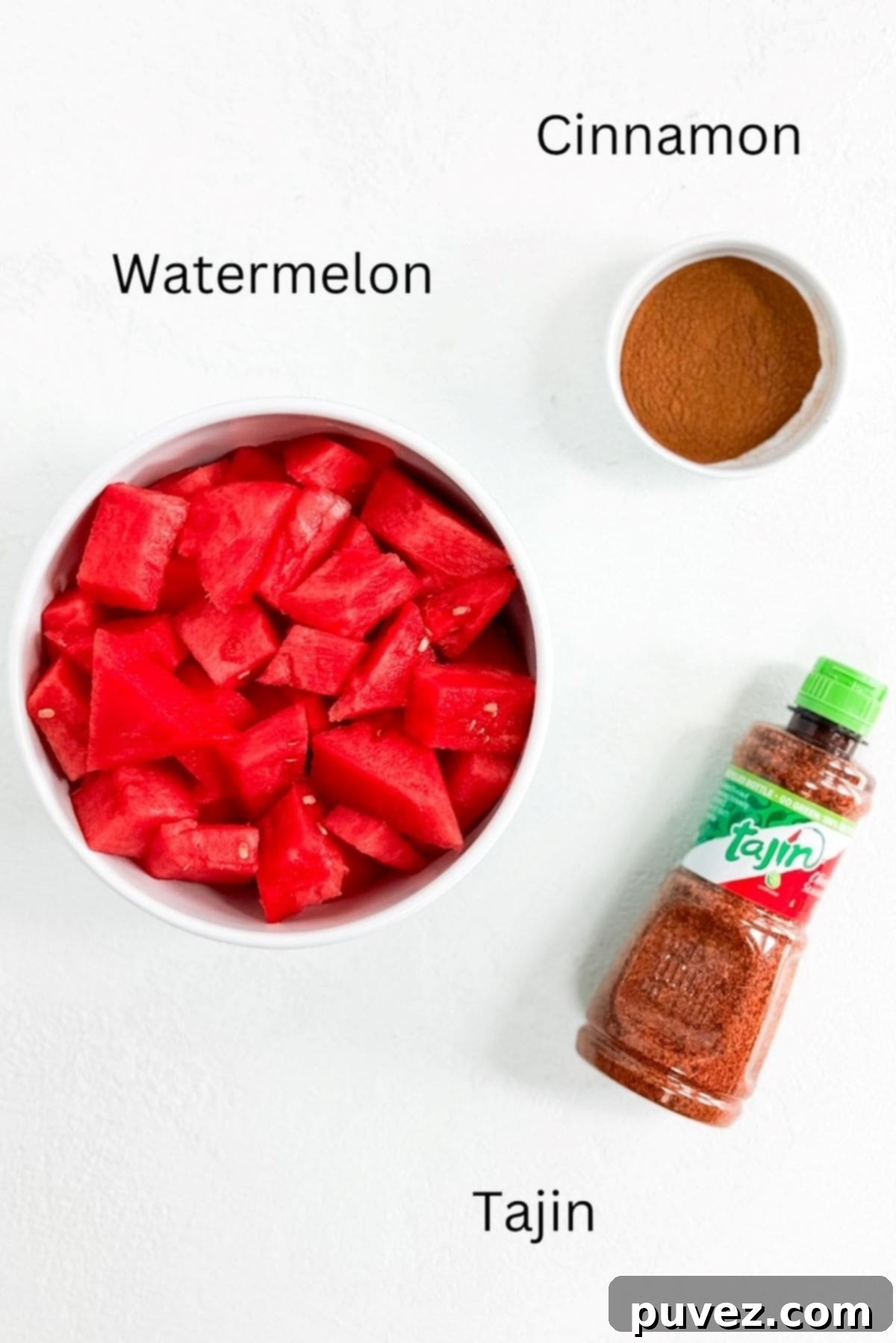 A bowl of fresh watermelon, a small bowl of cinnamon, and a bottle of Tajin seasoning – the three simple ingredients for this recipe.