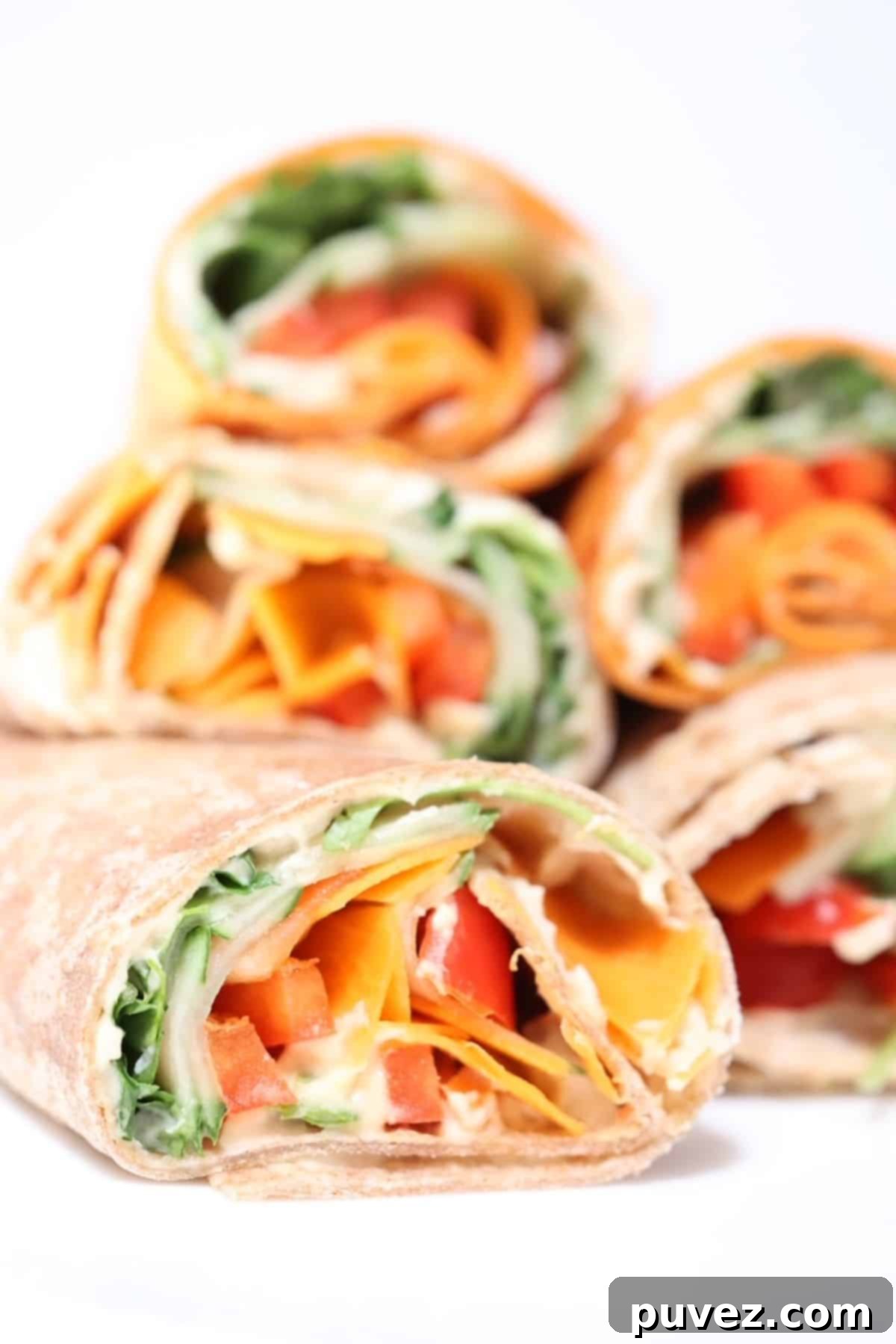 Five halves of veggie hummus wraps, stacked.