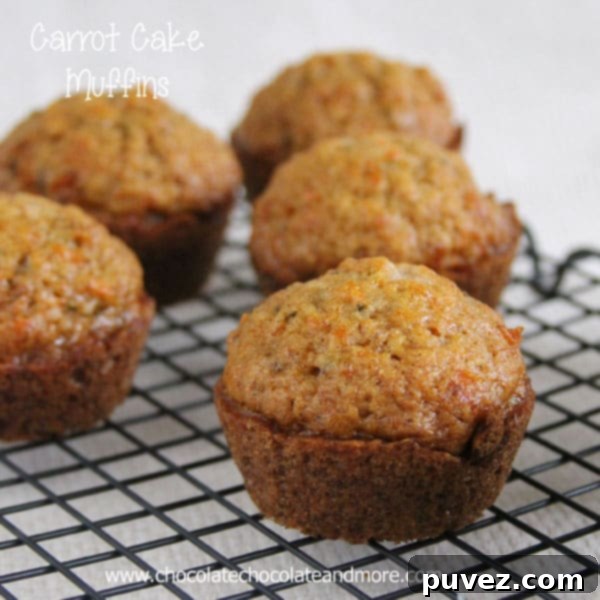 Close-up of a rustic kitchen counter with a batch of homemade Carrot Cake Muffins cooling.