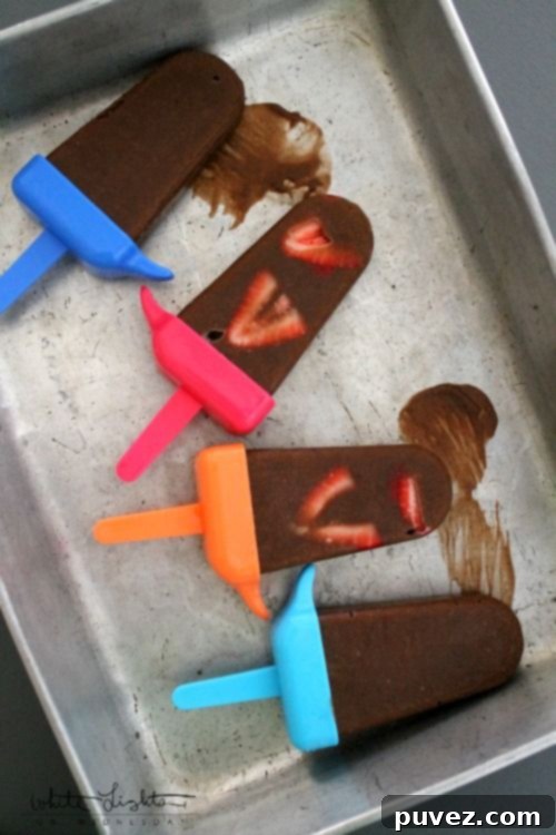 Decadent Chocolate Covered Strawberry Pudding Pops, a creamy and fruity frozen dessert.