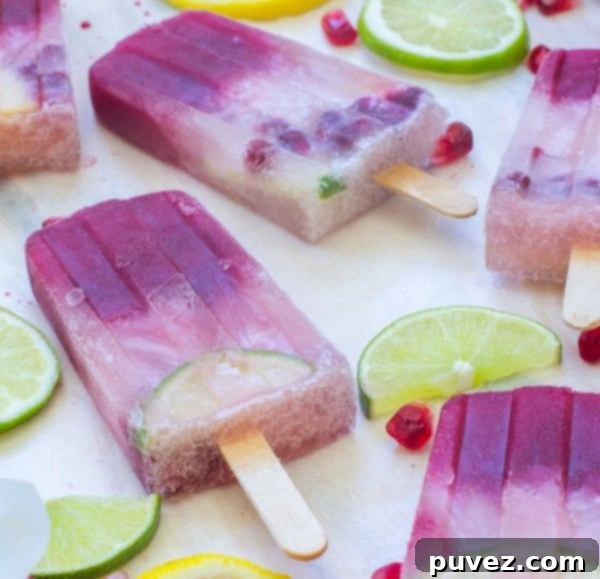 Sophisticated Pomegranate & Champagne Sangria Popsicles, an elegant frozen cocktail for adults.