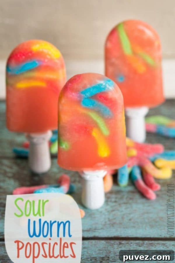Playful Sour Worm Popsicles, a tart and fruity frozen treat with fun gummy candies inside.