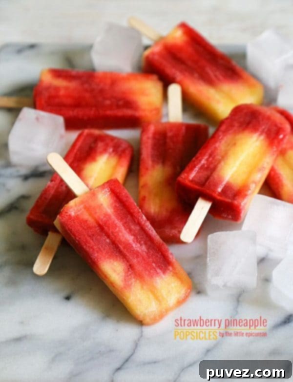 Vibrant Strawberry Pineapple Popsicles, a sweet and tangy tropical frozen treat for summer.