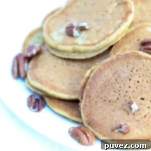 A plate of pumpkin pancakes topped with toasted pecans.