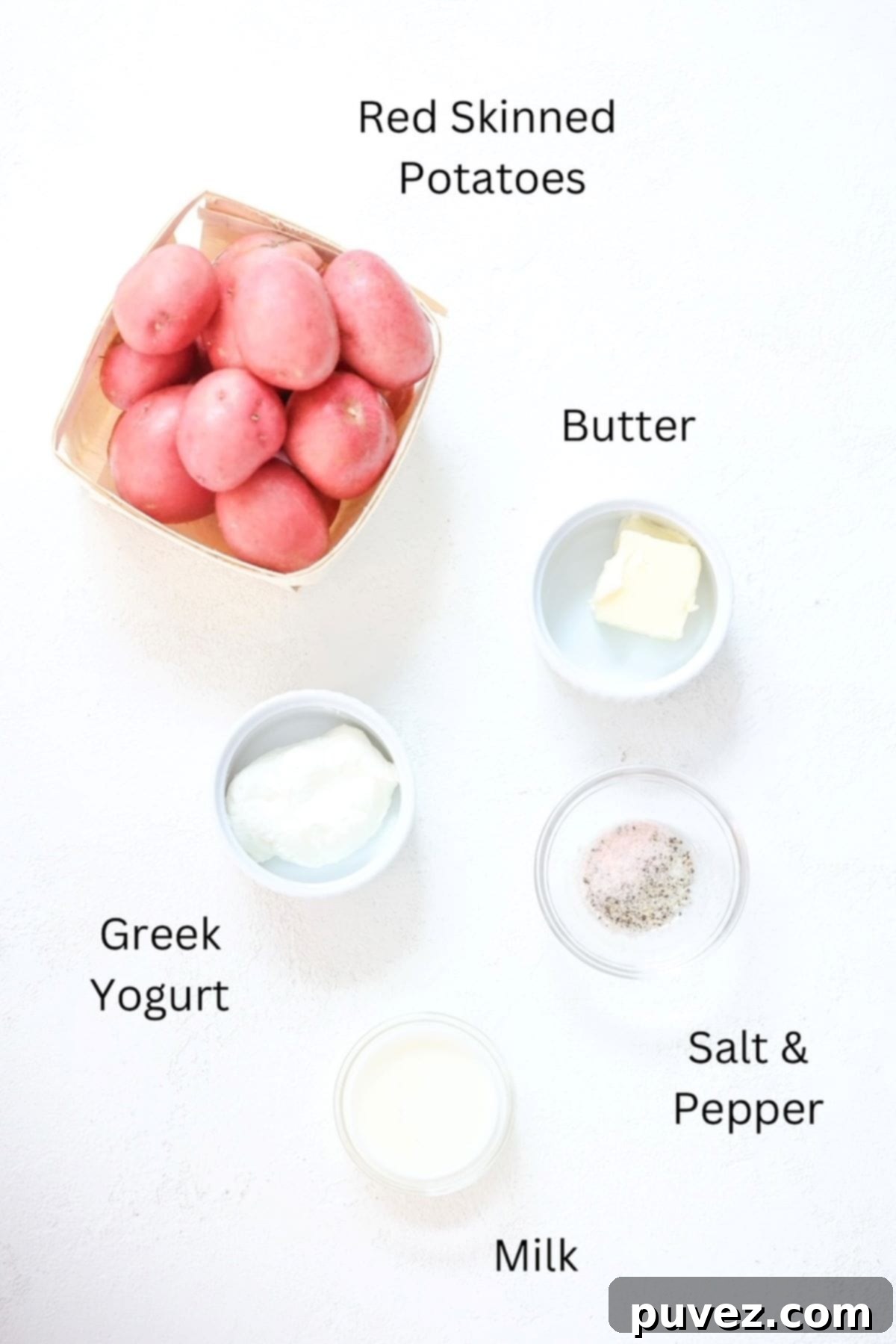 Ingredients for red skinned mashed potatoes, labeled: red potatoes, butter, Greek yogurt, milk, salt, and pepper.