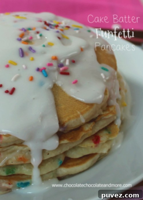 Stack of fluffy Cake Batter Funfetti Pancakes with a sweet glaze and colorful sprinkles