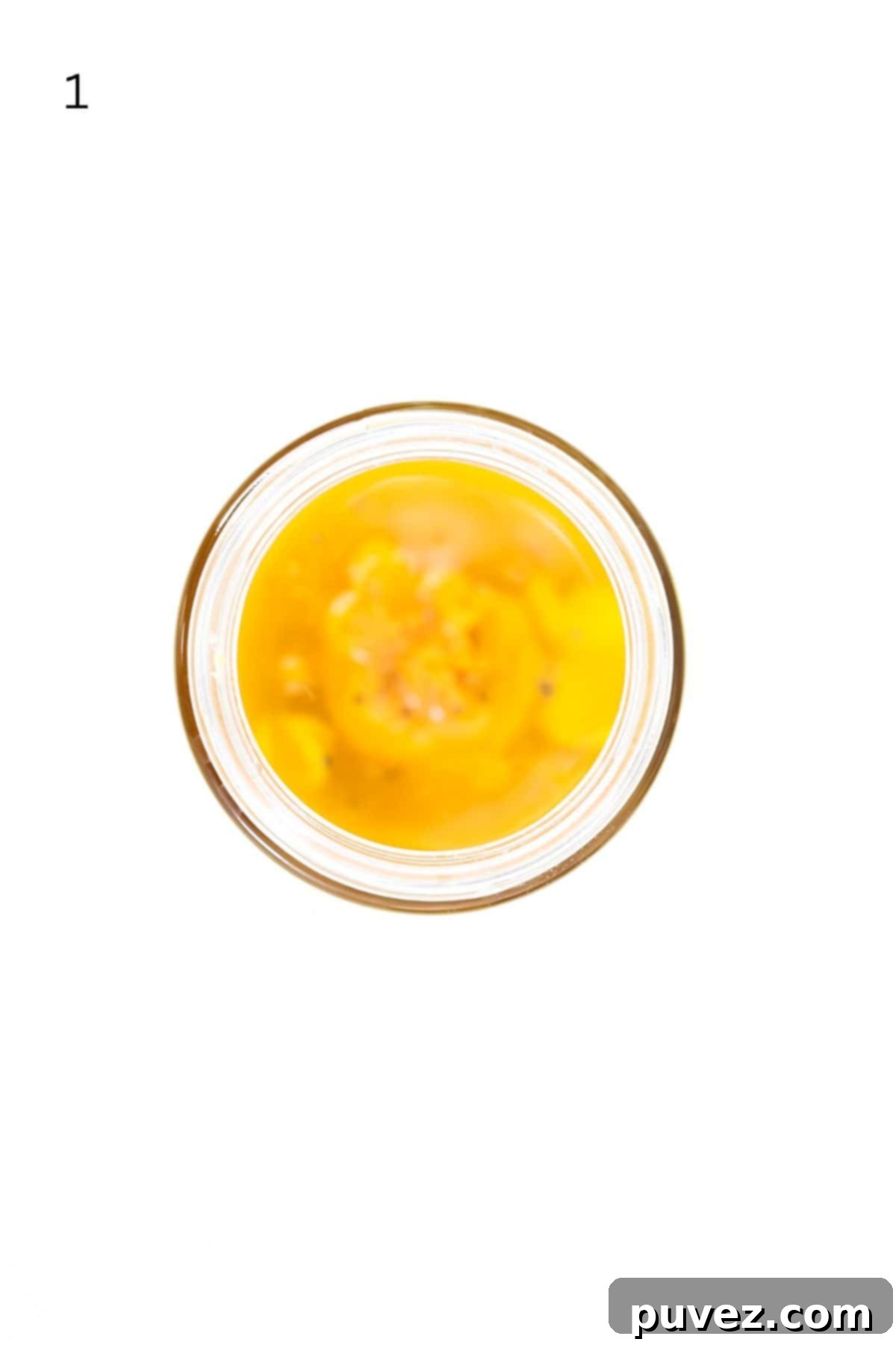 Bright Apple Vinaigrette 4 Top-down view of all apple cider vinaigrette dressing ingredients poured into a glass jar, showing distinct layers before mixing.