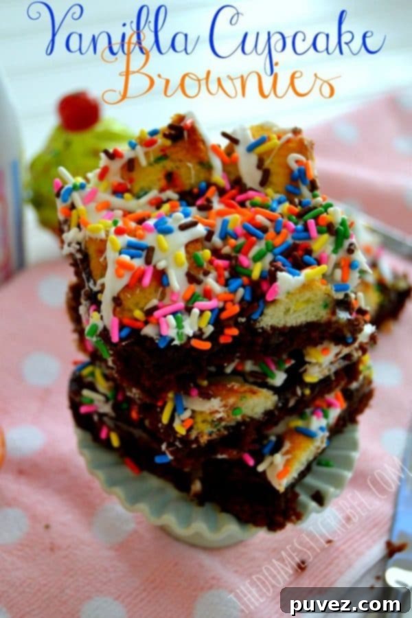 Vanilla Cupcake Brownies topped with white frosting and sprinkles.
