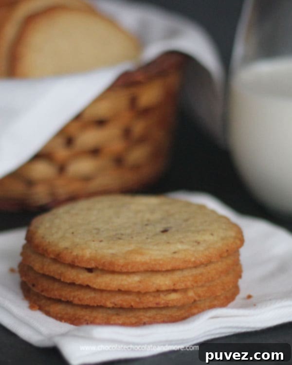 Stack of golden brown crisp almond cookies, showing their delicate thinness