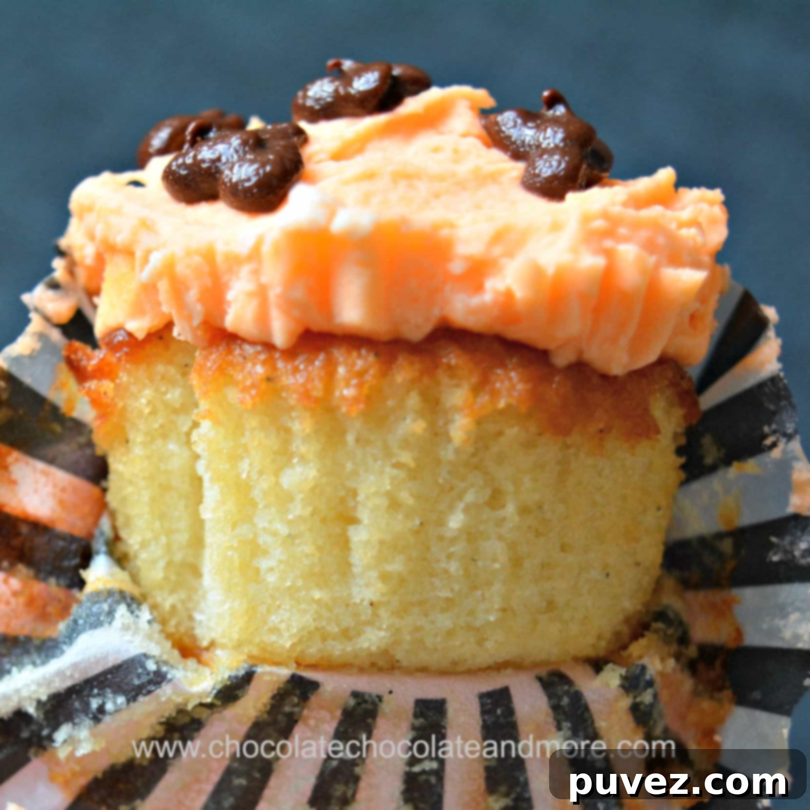 A perfectly baked, unwrapped yellow cupcake with a golden crumb