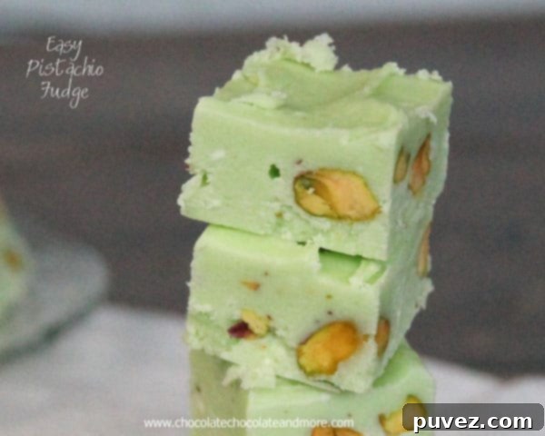 Close-up of a neatly cut square of Pistachio Fudge on a white background.