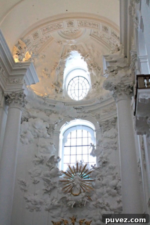 The stunning all-white main altar of Kollegienkirche Church in Salzburg, Austria, emphasizing purity and elegance.