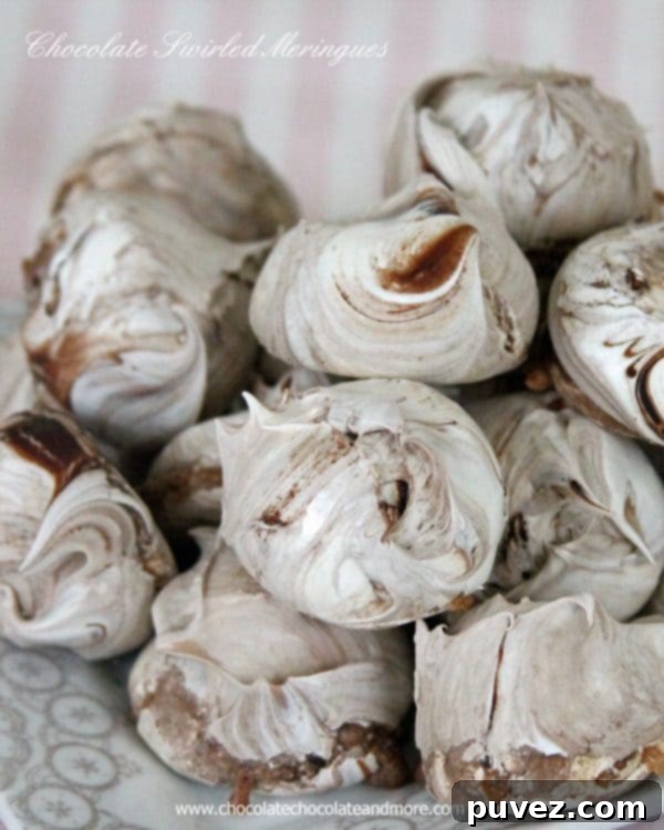 Freshly baked Chocolate Swirled Meringues cooling on a rack, showcasing their beautiful texture.