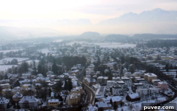 Panoramic view of Salzburg city from Hohensalzburg Fortress, showcasing historic buildings and rooftops.