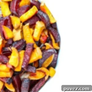 Roasted beets and sweet potatoes in a white bowl, ready to serve.