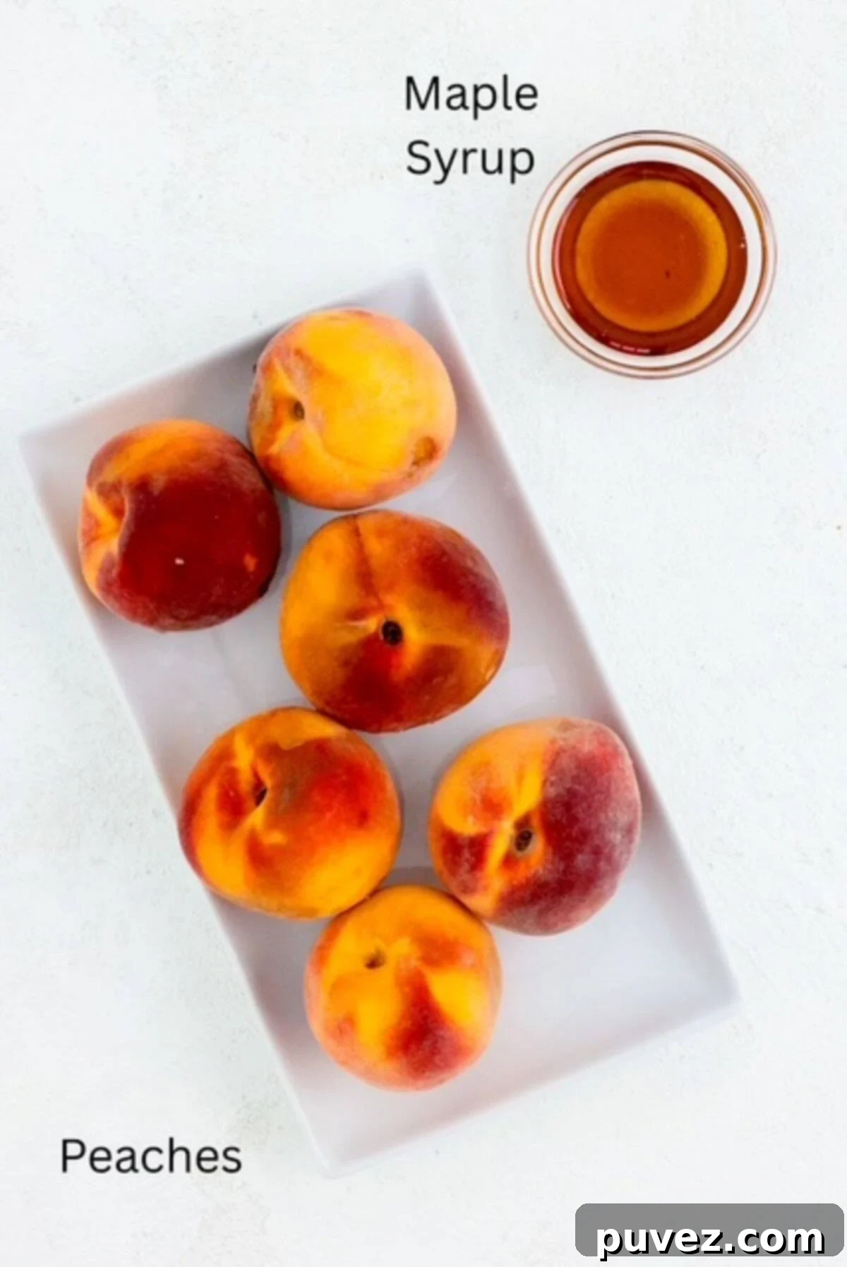 Ingredients for making roasted peaches, labeled, including fresh peaches and a small bowl of maple syrup.
