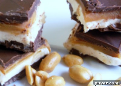 Homemade Snickers Bars, featuring layers of nougat, caramel, and peanuts coated in milk chocolate
